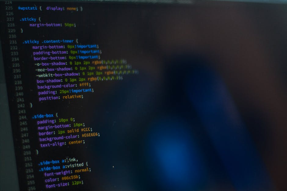 A close-up view of a computer screen displaying lines of colorful code in a dark-themed code editor. The code features different syntax highlighting colors such as green, yellow, purple, and blue, wit